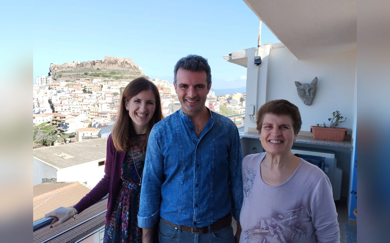 Letizia Pileri con la famiglia sul terrazzo, con il castello di Castelsardo sullo sfondo