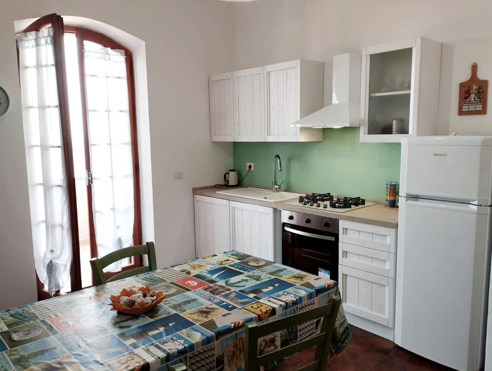 La cucina con il tavolo da pranzo e la porta finestra sul terrazzo