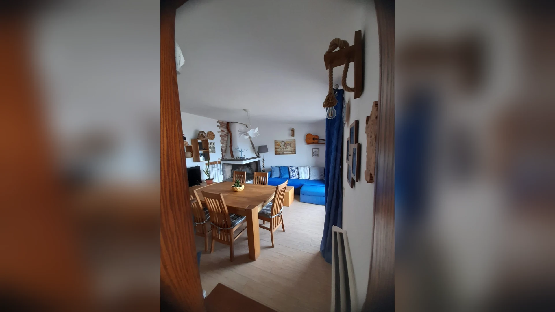 Il soggiorno di Cara a' Mari con il camino d'arredo e il divano blu