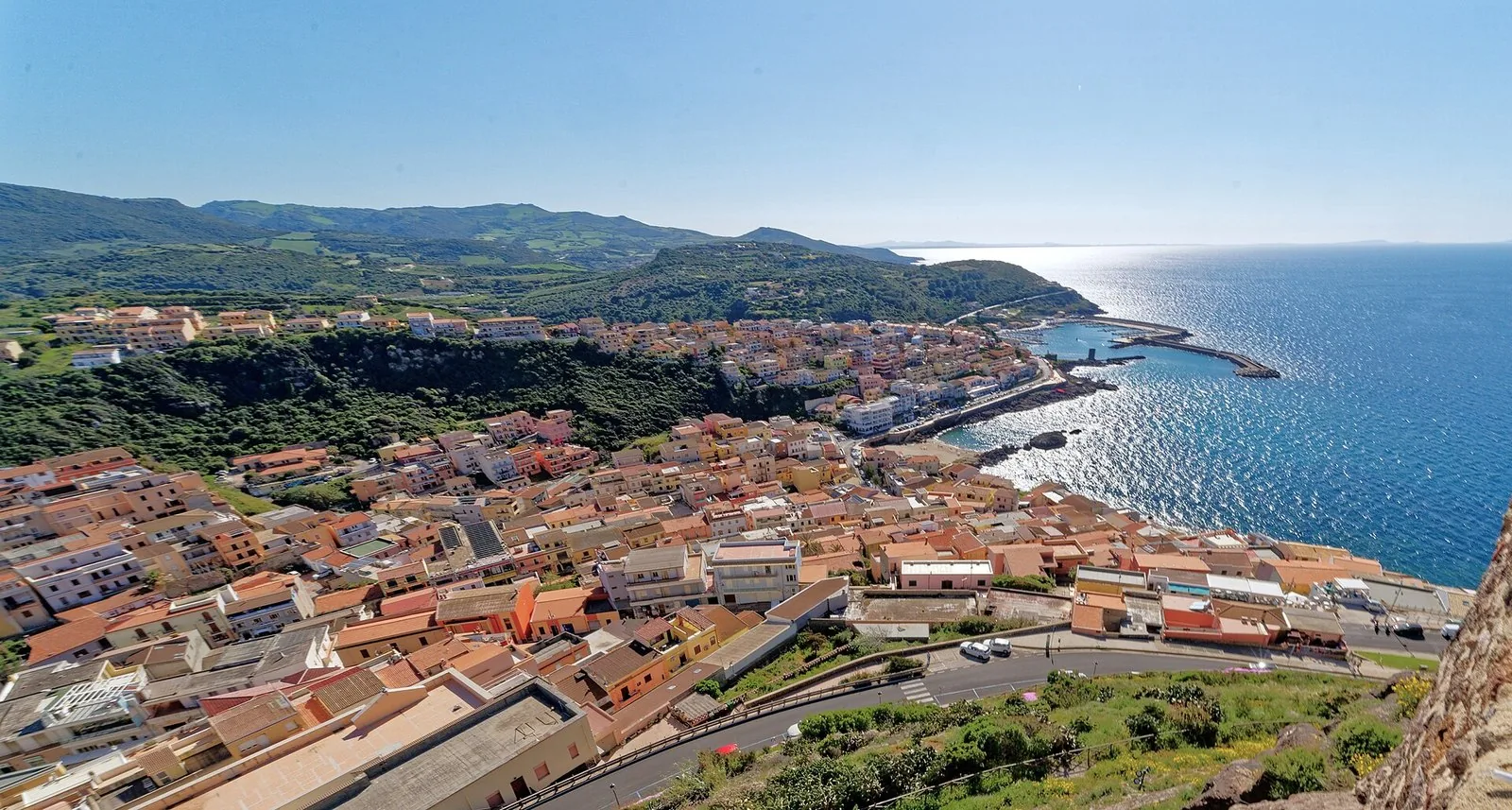 Vicolo in salita nel centro storico di Castelsardo, con case in pietra e scalinata deserta