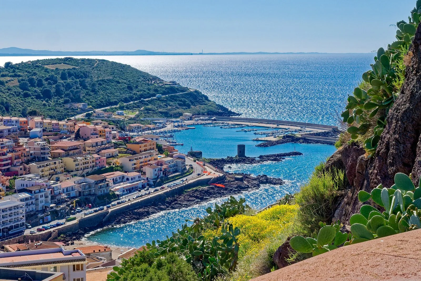 La spiaggia di Lu Bagnu a Castelsardo con il promontorio del borgo medievale sullo sfondo