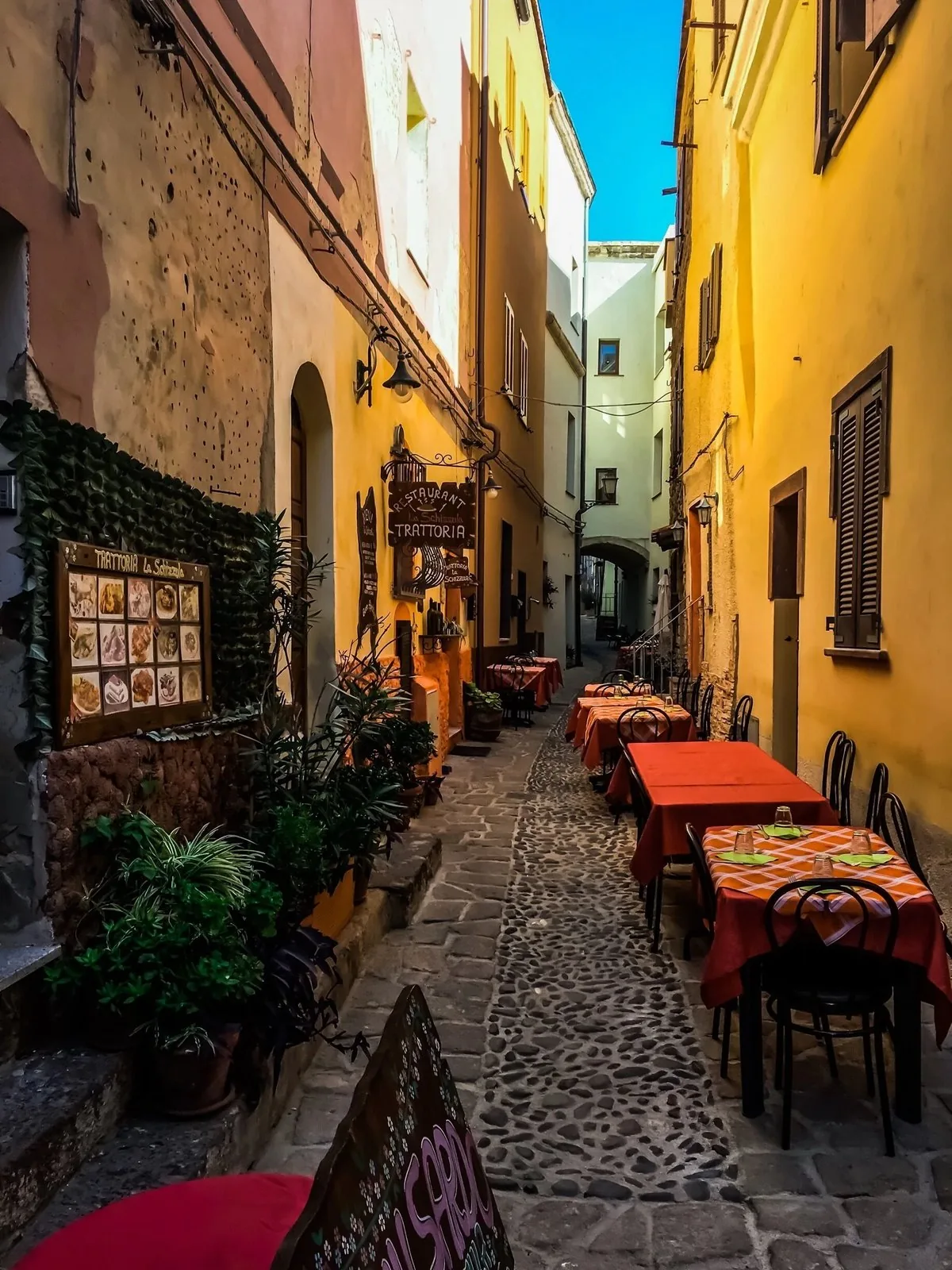 Un vicolo acciottolato del centro storico di Castelsardo con tavoli all'aperto