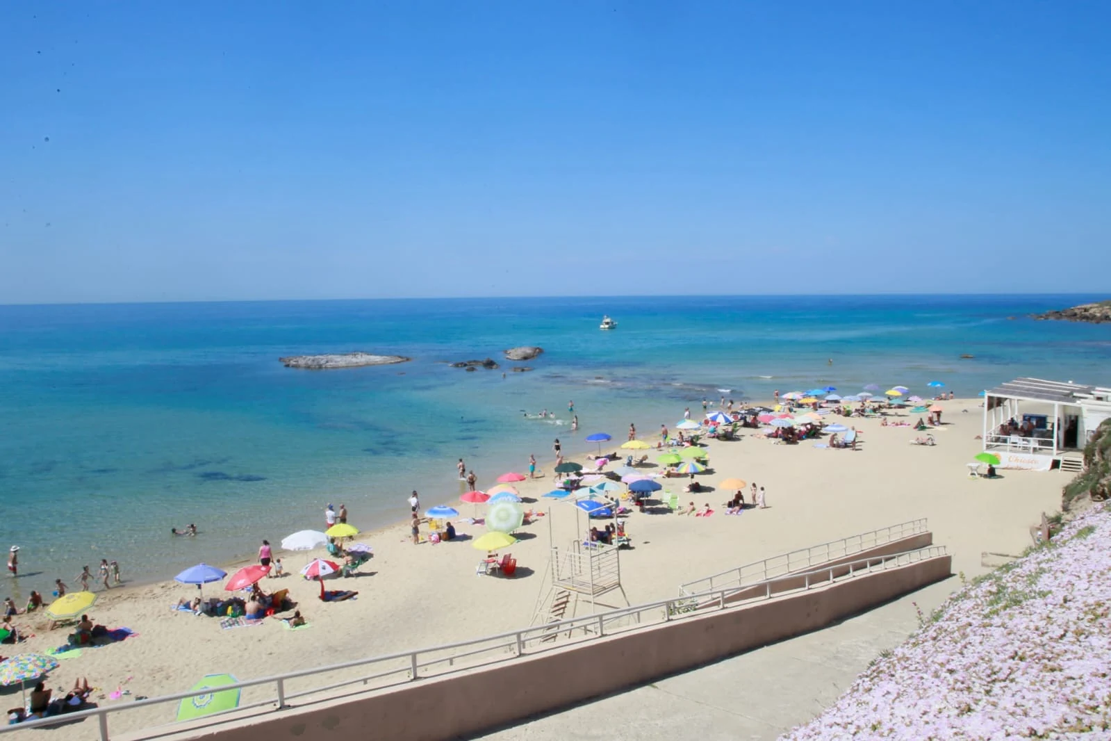La spiaggia di Lu Bagnu con ombrelloni e mare turchese, a due chilometri da Castelsardo